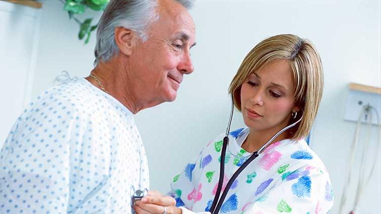 A nurse uses a stethescope on a patient